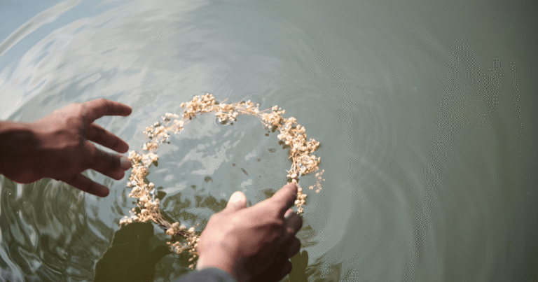 Egy kéz koszorút helyez a vízre